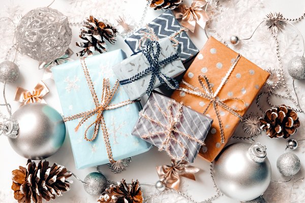 Geschenke mit losem Tee, Teelicht, Teedose und Kandis auf einem Untersetzer stehend als Geschenk